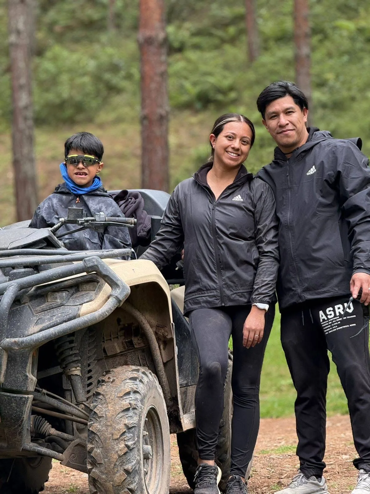 Familia junto a cuatrimoto en bosque